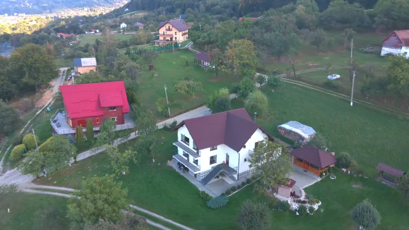 Casa din Livadă văzută din dronă, cu fațada, foișorul și grădina în cadru
