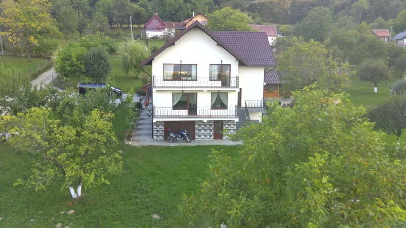 Fațada și balcoanele casei fotografiate din dronă, deasupra pomilor